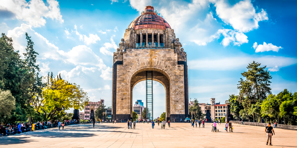 Avión de Papel, Noticias, Monumento a la Revolución, Ciudad de México, atardecer, personas caminando.